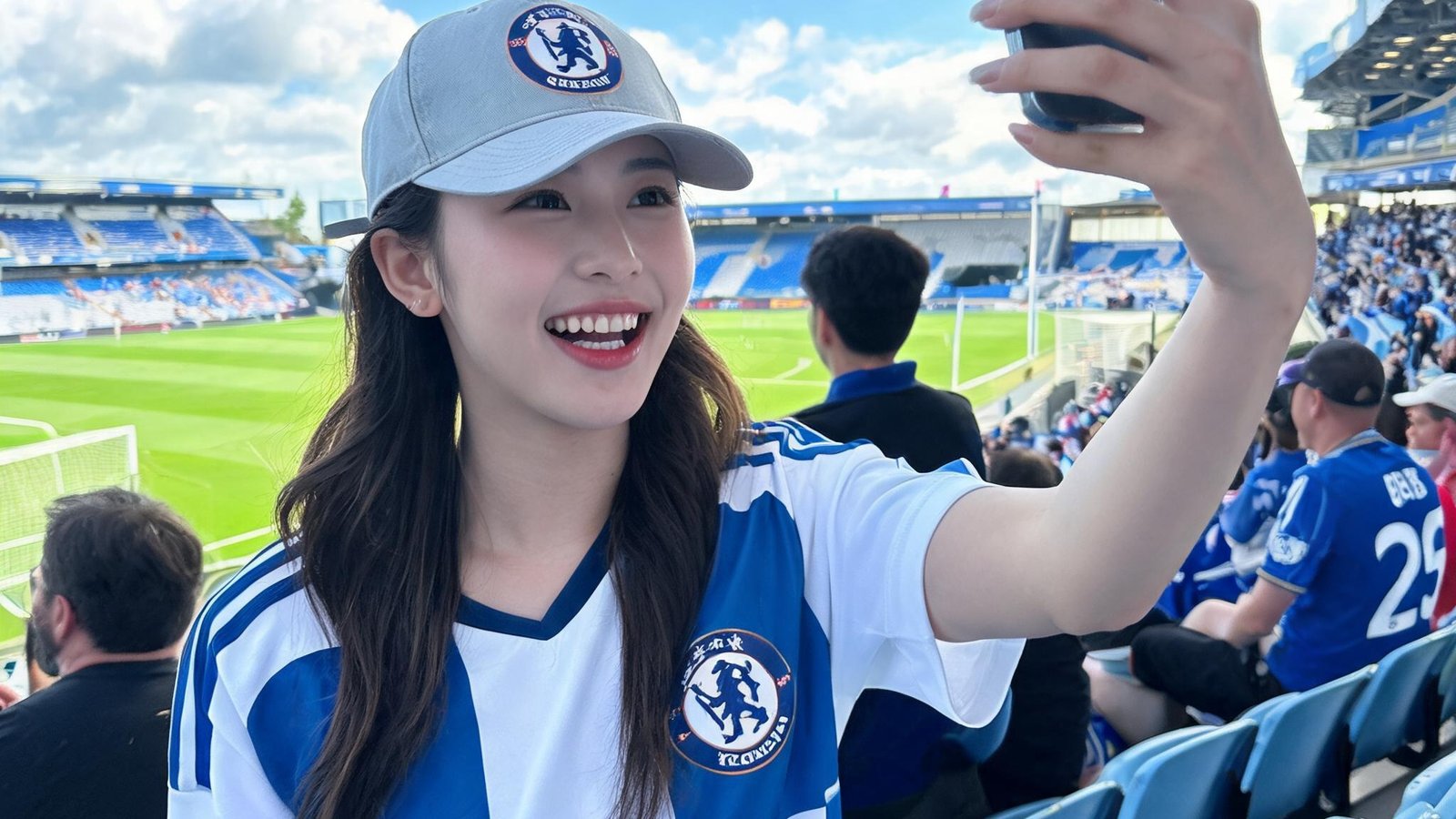 24岁女性女足球迷，戴棒球帽，在球场自拍